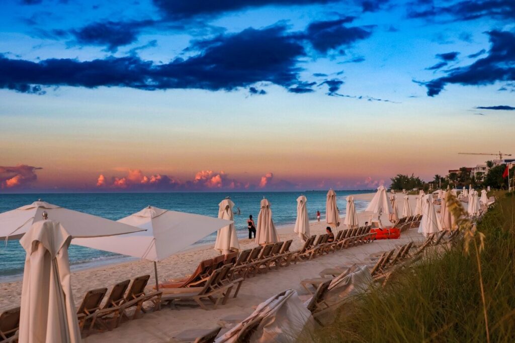 Viajar a Turcas y Caicos en modo low cost: guía 2026 A row of beach chairs sitting on top of a sandy beach