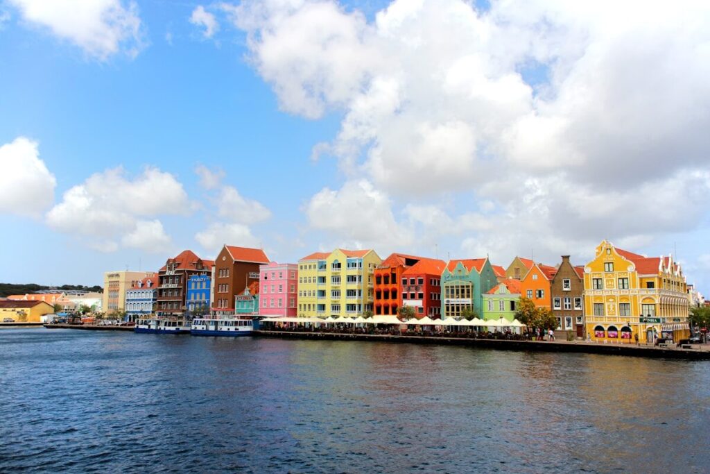 Ruta auténtica de 3 días en Willemstad, Curazao a row of colorful buildings on the side of a body of water