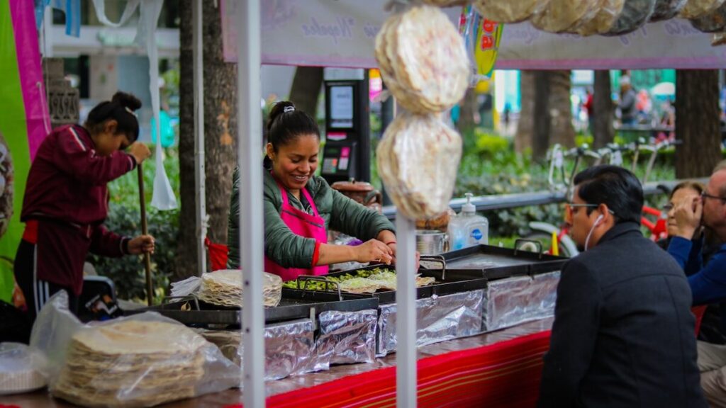 Street food en el Caribe: una guía completa woman cooking front of man watching over