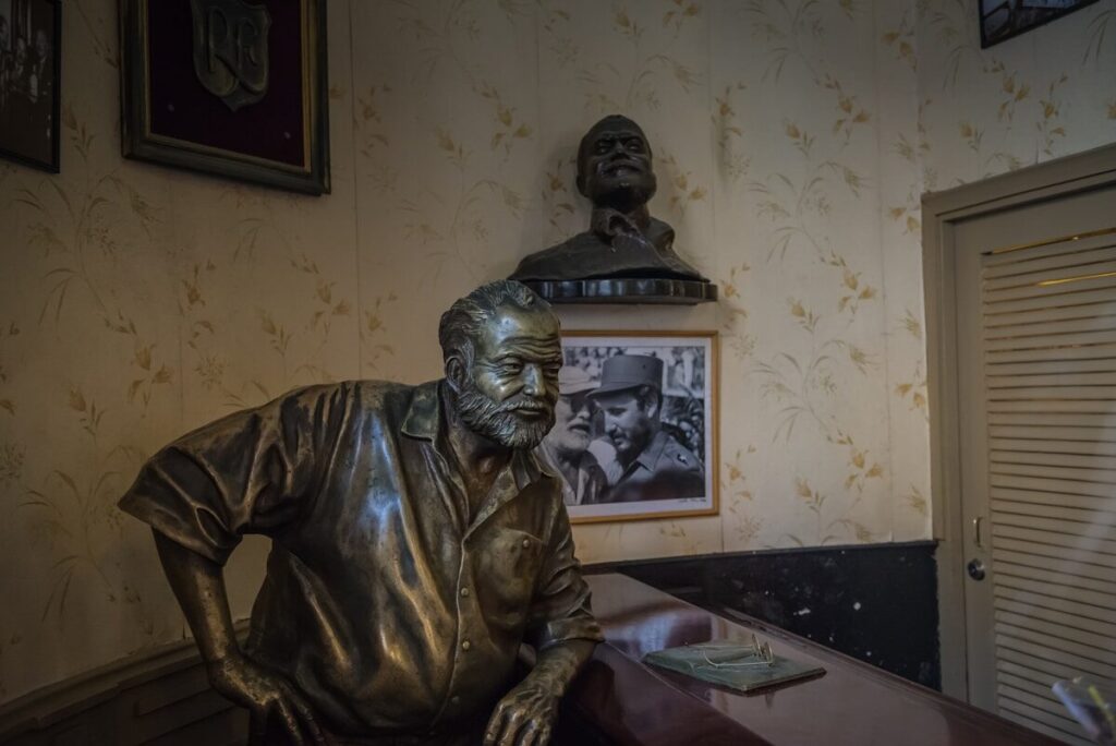 Rutas hemingwayanas en el Caribe: guía 2026 a bronze statue of a man sitting at a desk